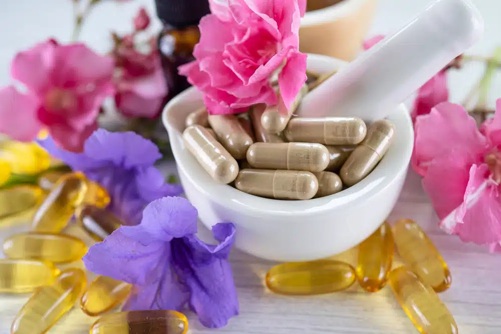 supplement capsules surrounded by flowers